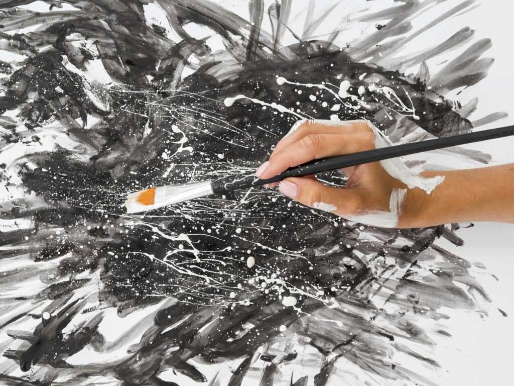 high angle hands holding brush with paint